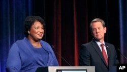 Kandida demokrat pou plas gouvènè nan Eta Jòji, Stacey Abrams (agoch) ki t ap fè deba avèk opozan repibliken li a, Brian Kemp, nan vil Atlanta, 23 oktòb 2018.