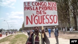FILE - A man holds a placard reading, "Congo is not the property of Nguesso," during a demonstration against President Denis Sassou Nguesso in Brazzaville, Republic of Congo, Sept. 27, 2015.