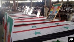 Pemakaman massal korban yang tewas akibat serangkaian pemboman bunuh diri yang dilancarkan oleh ISIS di kawasan Sweida, Suriah, Kamis, 26 Juli 2018. (SANA via AP). 