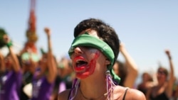 Una manifestante en un grupo brasileño de mujeres hace un gesto mientras canta la canción "El violador eres tú", que se hizo famosa en Chile. La marcha es con motivo del Día Internacional de la Mujer en Río de Janeiro, Brasil, el 8 de marzo de 2020.