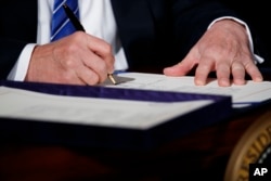 President Donald Trump signs the "Department of Veterans Affairs Accountability and Whistleblower Protection Act of 2017" in the East Room of the White House, June 23, 2017, in Washington.
