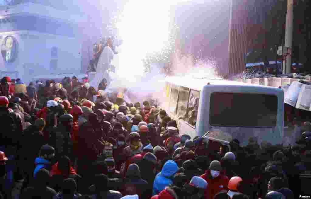 Người biểu tình Ukraina ủng hộ hội nhập châu Âu tấn công chiếc xe cảnh sát trong cuộc biểu tình gần các trụ sở hành chính của chính phủ. Người biểu tình tấn công cảnh sát chống bạo động bằng gậy gộc và tìm cách lật một chiếc xe buýt chận đường họ đến tòa nhà quốc hội ở Kiev, 19/1/14