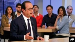 French President Francois Hollande gestures as he takes part in a live television program at Canal+ headquarters in Paris, April 19, 2015.