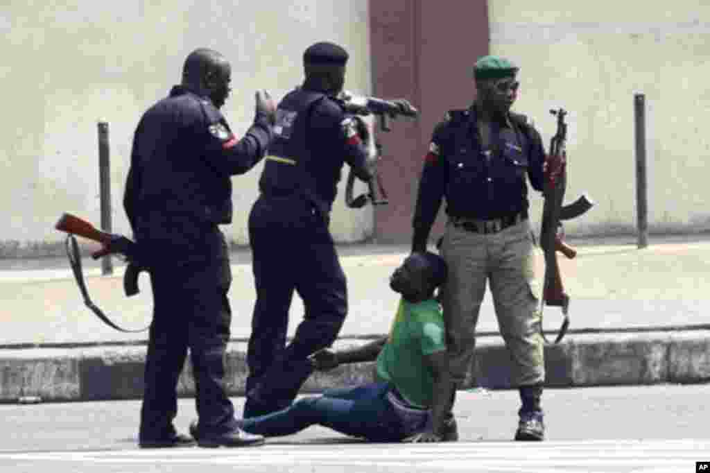 Policemen beat up a protester during a rally against fuel subsidy removal on Ikorodu road in Nigeria's commercial capital Lagos January 3, 2012. Hundreds of demonstrators in Nigeria's commercial capital Lagos shut petrol stations, formed human barriers al
