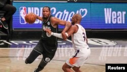 Kevin Durant (7) des Brooklyn Nets passe devant Chris Paul (3) des Phoenix Suns au Barclays Center, New York, le 25 avril 2021.