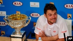 Petenis Swiss, Stanislas Wawrinka dengan trophy juara Australia Terbuka saat melakukan konferensi pers di Melbourne, Australia hari Minggu (26/1). 