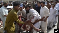 People rush an injured man to hospital following a bomb blast near a rally by the Awami National Party that killed at least five people, in Quetta, Pakistan, Friday, July 13, 2012.