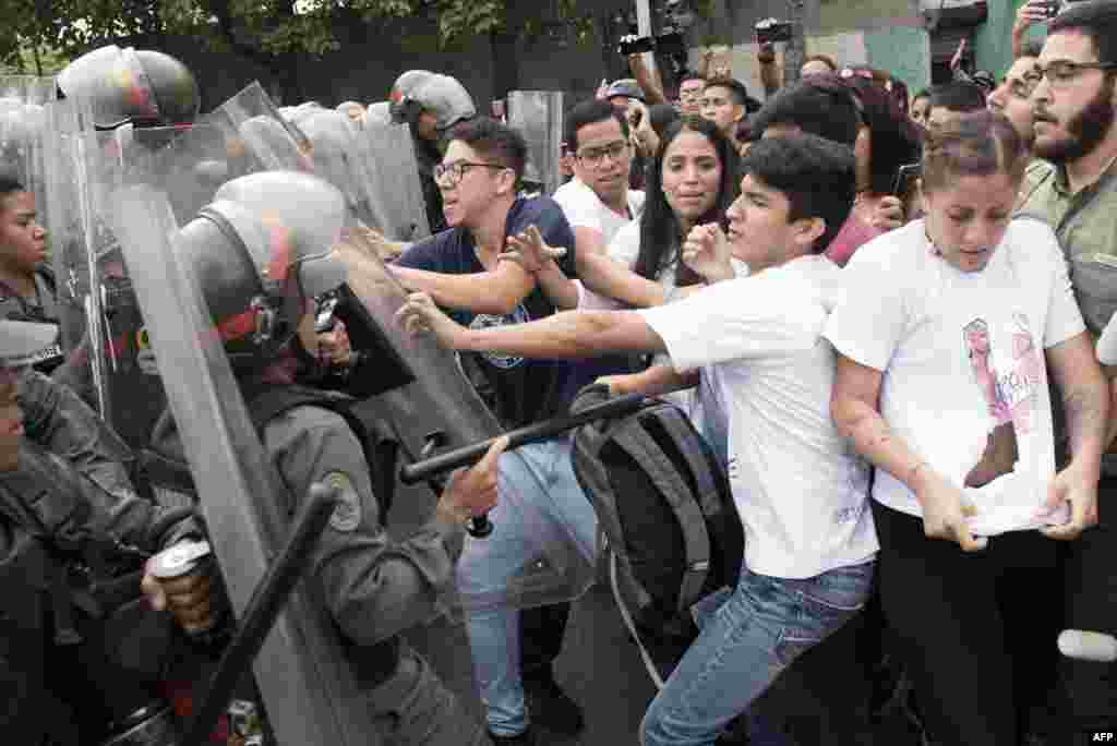 Venezuelan opposition activists scuffle with National Guard personnel in riot gear during a protest in front of the Supreme Court in Caracas, March 31, 2017.