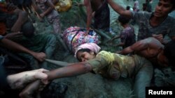 一名从缅甸越境逃到孟加拉国边界的罗兴亚妇女在其他人的帮助下爬上纳德河的河岸。（2017年11月1日）