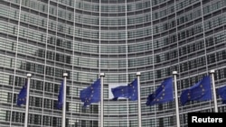 European Union flags are seen outside the European Commission headquarters in Brussels in this October 27, 2010, file photo.