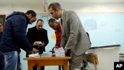 Election workers count ballots at the end of three-day vote of the referendum on constitutional amendments at polling station in Cairo, Egypt, Monday, April 22, 2019.