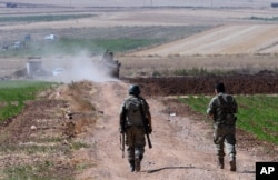 FILE - Turkish soldiers patrol near the border with Syria, outside the village of Elbeyli, east of the town of Kilis, southeastern Turkey, July 24, 2015.