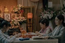 秀英阿嬷与女儿和孙女在灵堂里折纸莲花。（威视电影授权提供）