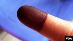 A Cambodian voter displays an ink stained finger after casting his ballot, July 28, 2013. (VOA / Heng Reaksmey)