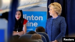 FILE - US Democratic presidential nominee Hillary Clinton talks to staff members, including aide Huma Abedin (L), on board her campaign plane in White Plains, New York, U.S. Oct. 28, 2016. 
