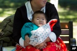 FILE - A child is wrapped up against the cold at a park in Beijing, China.