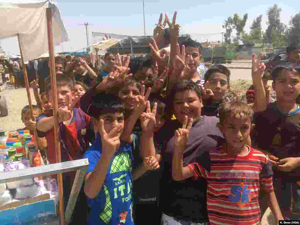 Children raise their hands, doing the V sign, in the Intisar neighborhood (left side of Mosul), July 19, 2017.