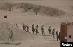 FILE - Pakistan Rangers walk with their weapons during a counterterrorism training demonstration on the outskirts of Karachi, Pakistan, Feb. 24, 2015.
