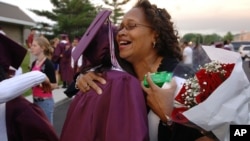 Laquetta Smith, right, gives a congratulatory hug to Lauryn Scott, after the Kalamazoo Central High School graduation ceremony Wednesday, June 7, 2006, at Wings Stadium In Kalamazoo, Mich. Kalamazoo Central was the first graduating class to qualify for th