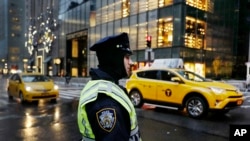 Seorang polisi Kota New York tengah mengawasi suasana di luar Trump TOwer di New York (5/12). 