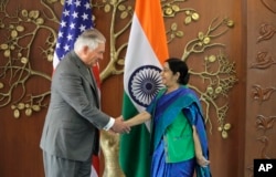 Indian Foreign Minister Sushma Swaraj, right, shakes hand with U.S. Secretary of State Rex Tillerson in New Delhi, India, Oct. 25, 2017.