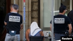 Un homme couvert avec une serviette a été arrêté par la police française dans le cadre de l'enquête lié à l'attentat de Nice, France, le 16 juillet 2016.