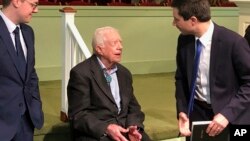 Democratic presidential candidate Pete Buttigieg, right, and his husband, Chasten Glezman, left, speak with former President Jimmy Carter, May 5, 2019 at former President Jimmy Carter's Sunday school class in Plains, Georgia. 