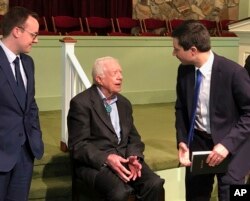 Democratic presidential candidate Pete Buttigieg, right, and his husband, Chasten Glezman, left, speak with former President Jimmy Carter, May 5, 2019 at former President Jimmy Carter's Sunday school class in Plains, Georgia.