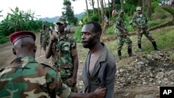 Les rebelles M23 appréhendent un homme soupçonné d'être un combattant des FDLR (Force démocratiques pour la libération du Rwanda) de retour d'une incursion au Rwanda, près de Kibumba, au nord de Goma, 27 novembre 2012.