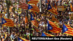 Manifestantes independentistas catalanes marchan con su bandera, conocida como "Estelada", en Barcelona para pedir la libertad de políticos presos. 15 de abril de 2018. 