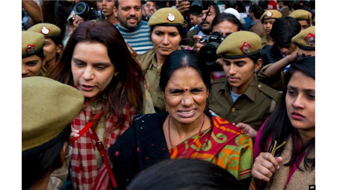 The mother (c) of the victim of the fatal 2012 gang rape that shook India arrives to lend her support at a protest in New Delhi, India, Dec. 21, 2015.