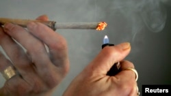 FILE - A person lights a cigarette.