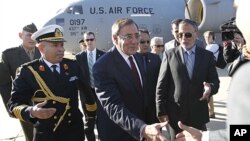 U.S. Secretary of Defense Leon Panetta greets members of the Libyan delegation on the tarmac during his arrival in Tripoli, Saturday, Dec., 17, 2011.