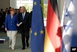 German Chancellor Angela Merkel, left, and and Israeli Prime Minister Benjamin Netanyahu arrive for a news conference after a meeting in Berlin, Monday, June 4, 2018.