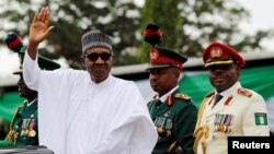 Nigerian President Muhammadu Buhari waves at the crowd while he drives around the venue during his inauguration for a second term in Abuja, Nigeria, May 29, 2019.