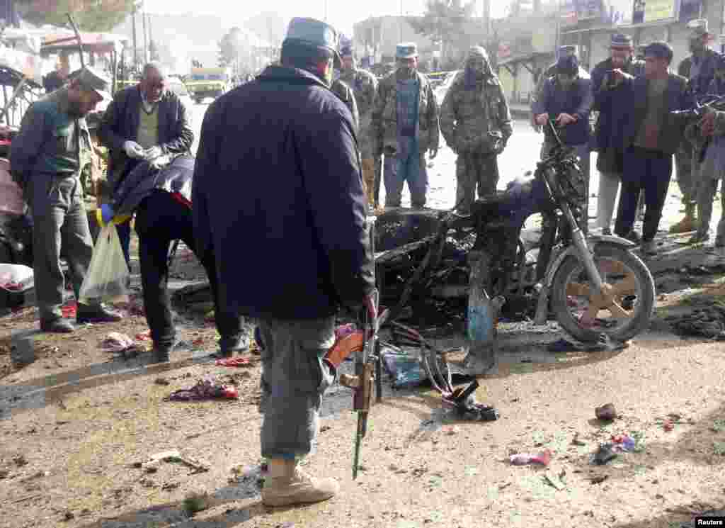 A police officer stands at the site of a suicide blast in Faryab, Afghanistan, March 18, 2014.