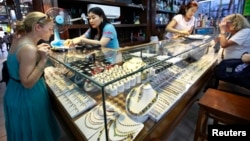 Tourists look at jade and gems in a shop at Aung San market in Rangoon, Burma, April 18, 2013. 