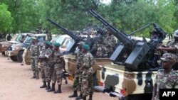 FILE - Cameroonian soldiers stand next to pick up trucks with mounted heavy artillery in Mora, northern Cameroon.