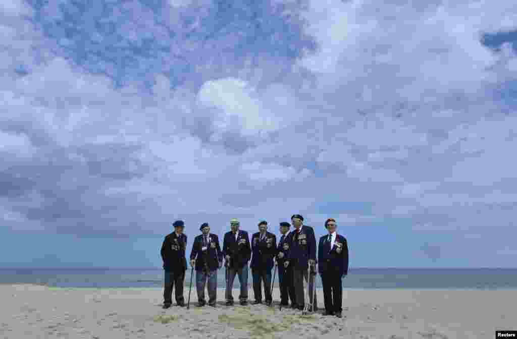British D-Day veterans, all from Wiltshire, stand on Sword Beach at Hermanville-sur-Mer on the Normandy coast, June 5, 2014. 