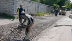 Pekerja mengaspal jalan lingkungan di wilayah Sleman, DI Yogyaakrta, dalam pekerjaan yang didanai dengan Dana Desa. (Foto: VOA/Nurhadi)