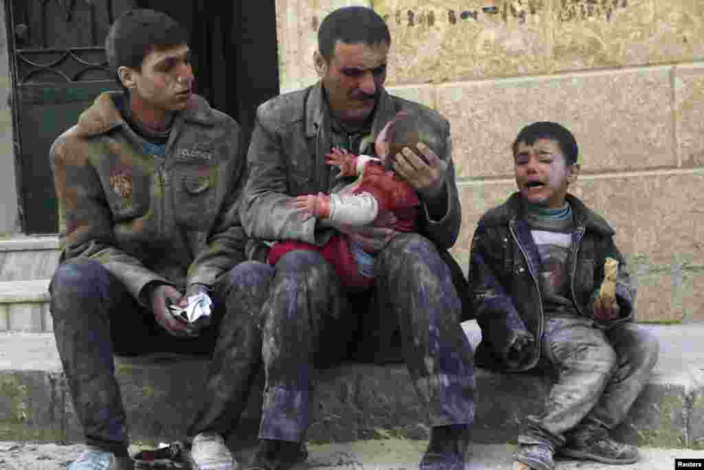 A man holds a baby saved from under rubble, who survived what activists say, was an airstrike by forces loyal to Syrian President Bashar al-Assad in Masaken Hanano in Aleppo, Feb. 14, 2014.