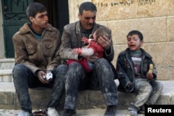 FILE - A man holds a baby saved from under rubble, who survived what activists say was an airstrike by forces loyal to Syrian President Bashar al-Assad in Masaken Hanano in Aleppo, Feb. 14, 2014.