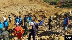 Soldiers carry the bodies of miners killed by a landslide in a jade mining area in Hpakhant, in Myanmar's Kachin state. Nov. 22, 2015. 