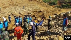 Soldiers carry the bodies of miners killed by a landslide in a jade mining area in Hpakhant, in Myanmar's Kachin state, Nov. 22, 2015. 