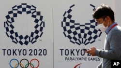  东京，一名男子走过东京奥运会和残奥会的标志。（2021年2月1日）