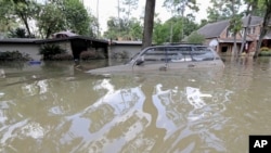 In this Sept. 4, 2017, file photo, a car is submerged in floodwaters in the aftermath of Hurricane Harvey near the Addicks and Barker Reservoirs in Houston, Texas. (AP Photo/David J. Phillip, File)