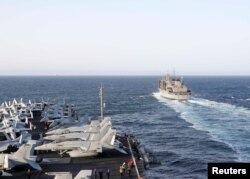 FILE - The Nimitz-class aircraft carrier USS Abraham Lincoln (CVN 72) pulls alongside the fast combat support ship USNS Arctic (T-AOE 8) for a replenishment-at-sea, in Arabian Sea, June 7, 2019.