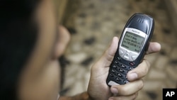 A Pakistani man with his mobile phone containing a prank message, Karachi, April 2007 (file photo).