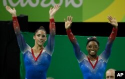 FILE - Aly Raisman, left, and Simone Biles wave after final results during the artistic gymnastics women's apparatus final at the 2016 Summer Olympics in Rio de Janeiro, Brazil, Aug. 16, 2016.