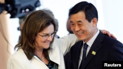 Maria das Gracas Silva Foster (L), CEO of Brazil's state oil company Petrobras, greets Bo Qiliang, President of CNODC, during a signing ceremony for the First Contract of Brazilian Pre-Salt, attended by Brazil President Dilma Rousseff, ministers and repre